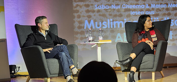 Saba-Nur Cheema und Meron Mendel auf der Bühne blicken zur Präsidentin